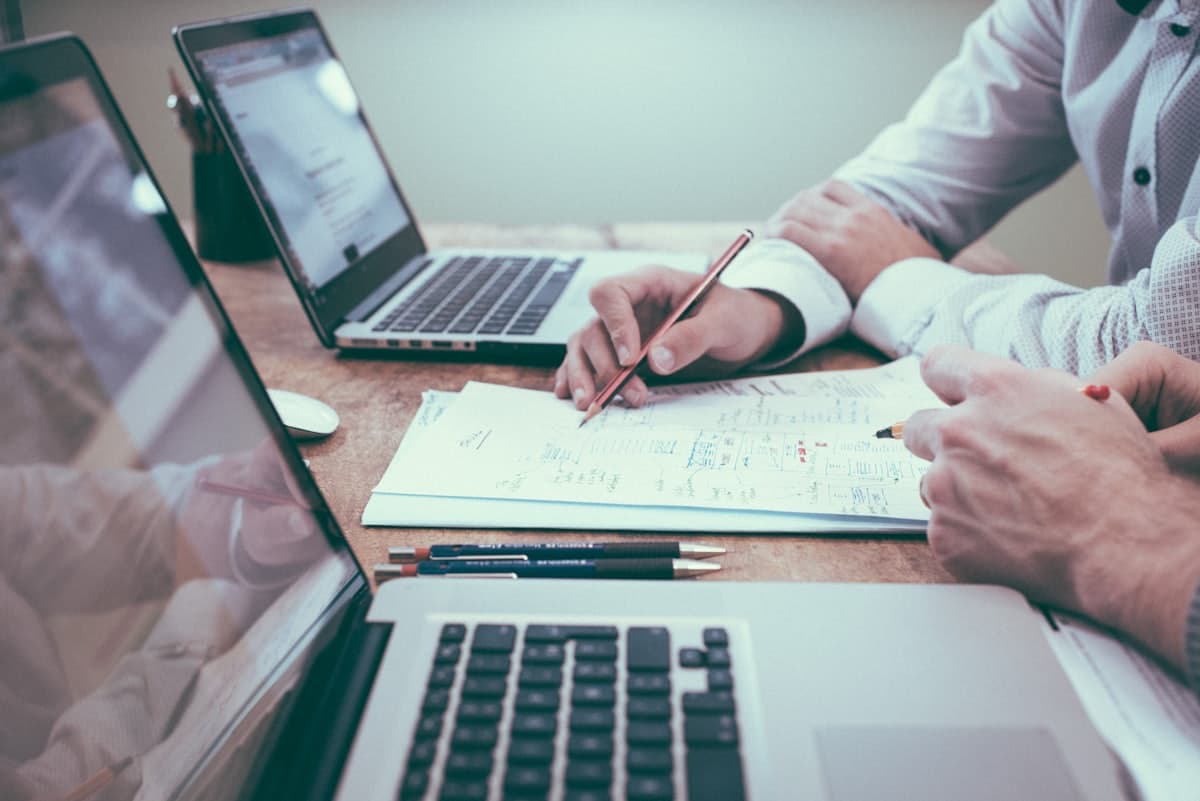Two colleagues reviewing printed financial workings together